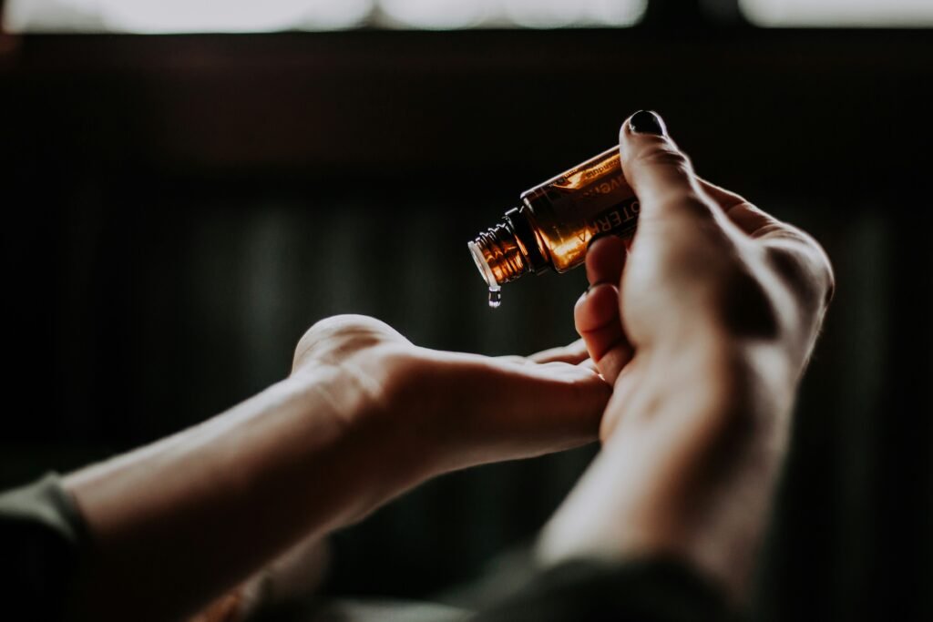 Person pouring essential oil into hand